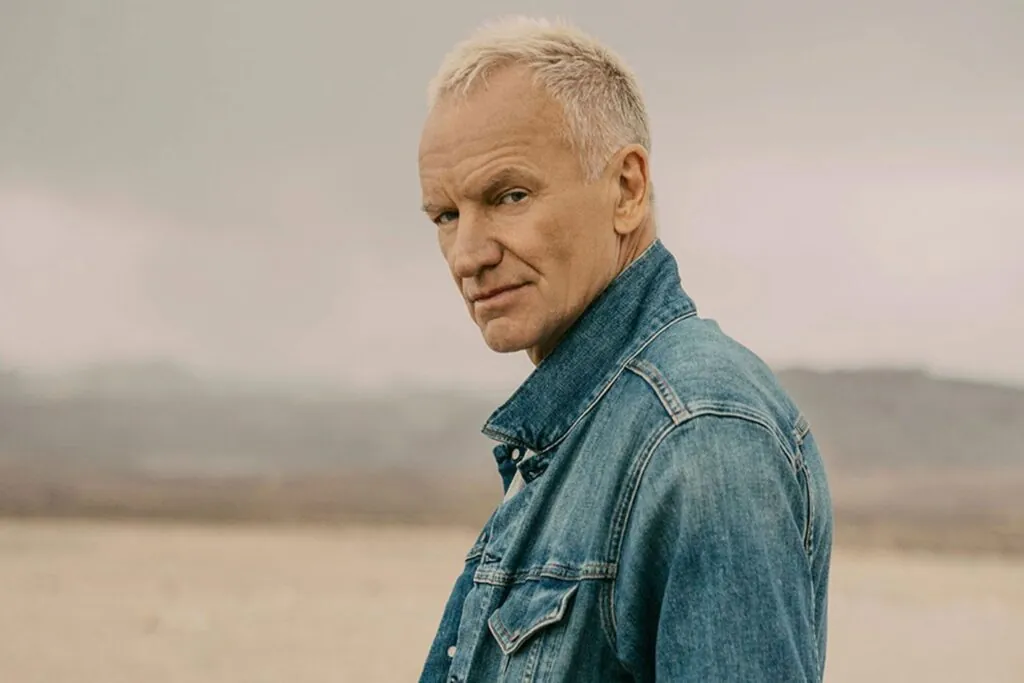 - Groovevolt Man with short blond hair wearing a denim jacket standing outdoors, looking at the camera with a calm expression.